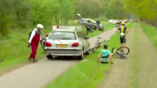 Jurywagen rijdt over fiets heen in PWZ Zuidenveldtour